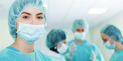 Young female surgeon with medical team in back before surgery