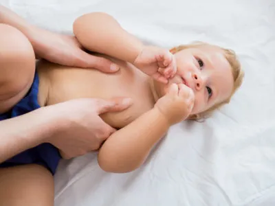 Baby girl receiving massage from mother at home