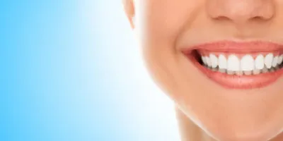 A woman is smiling while being at the dentist