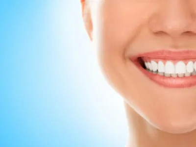 A woman is smiling while being at the dentist