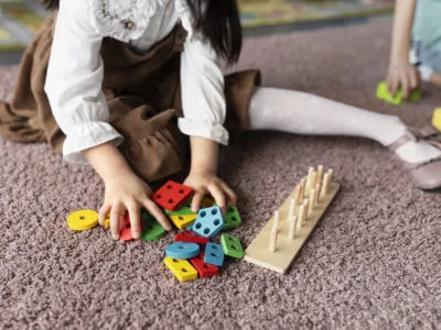 high-angle-kid-playing-with-colorful-toys